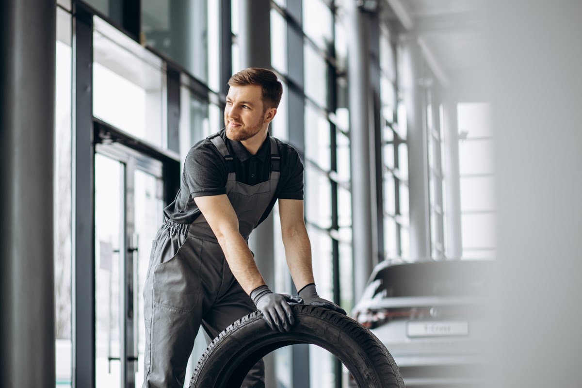 workman-car-repair-shop-changing-tires