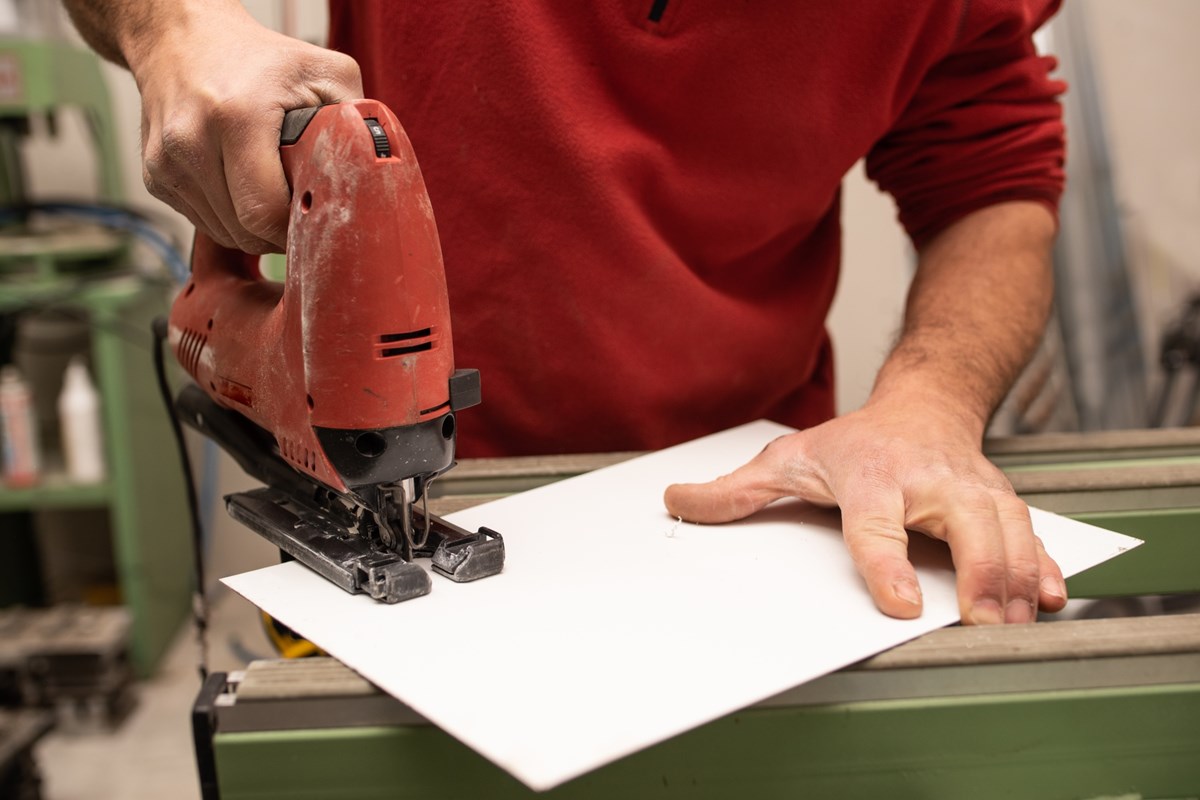young-male-with-red-sweater-making-something-with-industrial-tools